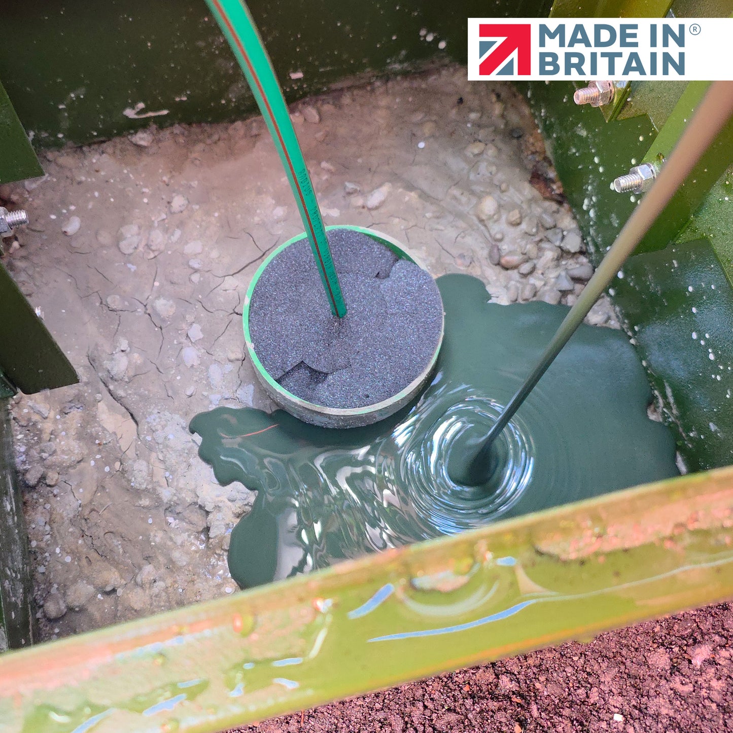 GreenStuff non-hazardous cabinet base sealant poured around cable ducts inside an outdoor cabinet, forming a smooth waterproof seal. Made in Britain logo visible.