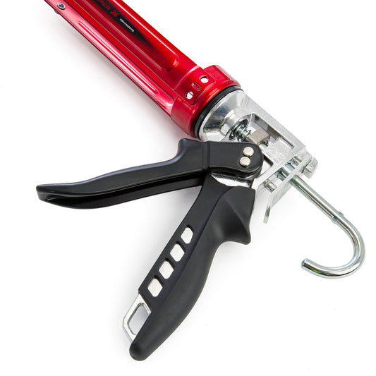 Tajima Convoy Super 26 caulking gun close-up showing red barrel, black ergonomic trigger handle, and metal hanging hook on a white background