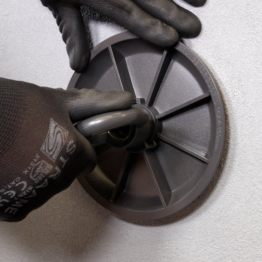 Installer with gloves tightening DuctPlug mechanical duct sealing plug using the pull-ring handle.