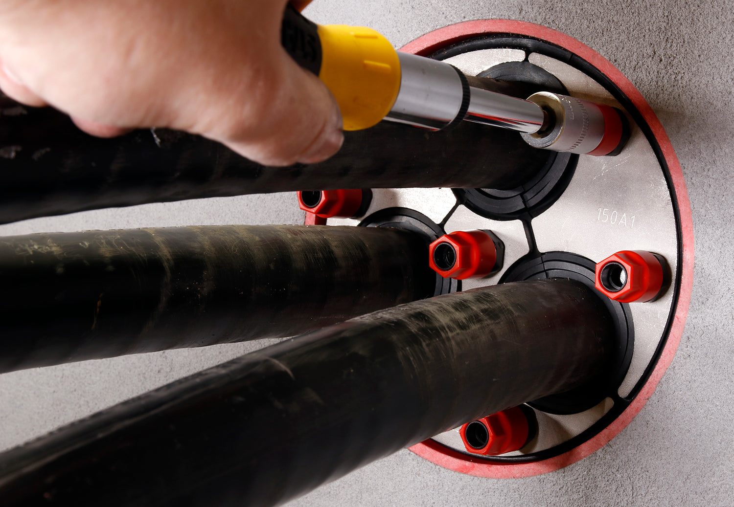 Technician tightening a KRASO duct sealing system with red and black cable seals, ensuring a secure and watertight installation — UK-manufactured and Made in Britain by Ductseal.